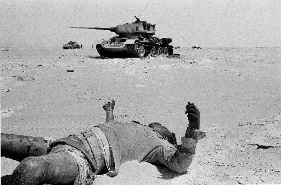 Un soldat égyptien gisant mort dans le désert du Sinaï. En arrière plan, un tank carbonisé de l'armée de Nasser. GETTY IMAGES